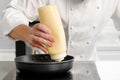 Close up of chef hand pouring sauce from gravy bottle into frying pan at commercial kitchen. Royalty Free Stock Photo