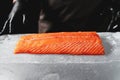 Close-up of chef hand prepared to cooking fresh salmon fille