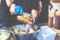 Close up of chef hands adding vegetables on fresh hot dog with grilled sausage Royalty Free Stock Photo