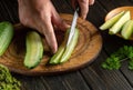 Close-up of a chef hands with a knife cutting a cucumber on a cutting board in a restaurant kitchen. Cucumbers Diet Idea Royalty Free Stock Photo