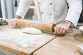 close up of chef hands rolling out dough Royalty Free Stock Photo