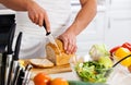 Close-up of a chef holding a baguette in front of a bamboo cutting board of apples, brie and pecans. Royalty Free Stock Photo