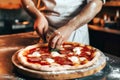 Close up of a chef preparing pizza in a restaurant kitchen
