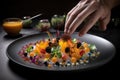 close-up of chef's hand, carefully arranging colorful and delicious ingredients on plate