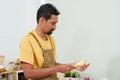 Close-up chef\'s hand-making breakfast, male chef wearing apron and both hands holding vegetable peeler, which has peel, Royalty Free Stock Photo