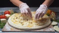 Close-up of chef`s hands adding a blue cheese in four cheeses pizza on a wooden board. Frame. Delicious pizza Royalty Free Stock Photo