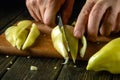 Close-up of a chef hands cutting a pepper with a knife. The idea of cooking a vegetable diet on the kitchen table in a restaurant Royalty Free Stock Photo