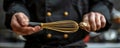 Chef Holding a Golden Whisk in a Professional Kitchen Setting CloseUp of Hands and Utensil Culinary Arts Concept Royalty Free Stock Photo
