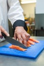 Close up of chef slicing raw salmon with sharp knife Royalty Free Stock Photo