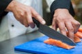 Close up of chef slicing salmon with sharp knife Royalty Free Stock Photo