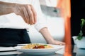 Close-up of a chef sprinkling French omelet with finely chopped herbs in a professional kitchen Royalty Free Stock Photo