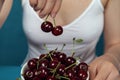 Close-up cherries in front of the female in white shirt