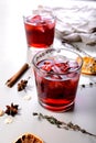 Close-up cherry wine cold cocktail. Alcoholic beverage still life. Dry oranges, cinnamon sticks, oregano, anise and dried ginger. Royalty Free Stock Photo