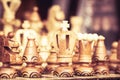 Close up of chessboard with wooden pieces on table in sunlight. Chess game, close up image with selective focus Royalty Free Stock Photo