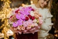 Close-up of chic expensive bouquet of pink flowers in round red box.