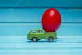 Close up of chicken egg on toy car on a blue wooden background. Abstract retro concept Royalty Free Stock Photo