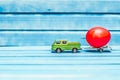 Close up of chicken egg on toy car with a trailer on a blue wooden background