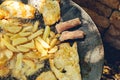 Close up of chicken meat and potato being grilled in a barbecue Royalty Free Stock Photo