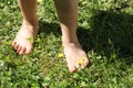 Close-up of a child barefoot on the lawn - a symbol of ecology