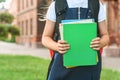 Close-up, A child of an elementary school student holds books in her hands and goes back to school. First day of study. Against. Royalty Free Stock Photo