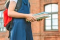 Close-up, A child of an elementary school student holds books in her hands and goes back to school. First day of study. Against. Royalty Free Stock Photo
