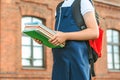 Close-up, A child of an elementary school student holds books in her hands and goes back to school. First day of study. Against. Royalty Free Stock Photo
