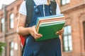 Close-up, A child of an elementary school student holds books in her hands and goes back to school. First day of study. Against. Royalty Free Stock Photo