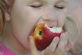 Close up Child Girl Eating Organic Apple in Orchard. Harvest Concept. Garden, Toddler eating fruits at fall harvest Royalty Free Stock Photo