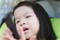 Close up child girl serious face. Beautiful kid speaking. Baby sitting on green stroller. Royalty Free Stock Photo