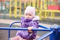 Close-up of a child of a girl sitting on a carousel on a playground Royalty Free Stock Photo