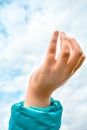 Close up of child hand raised up over blue sky and clouds background. Gesture Royalty Free Stock Photo