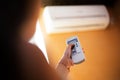 Close-up of child hand hold conditioner remote control. Orange background. Royalty Free Stock Photo