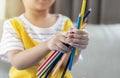 Close up of a child hand holding many colorful pencils while playing art paint at home Royalty Free Stock Photo