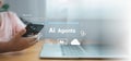 Close up of child hand using smartphone and laptop with AI Agents interface icons, automation technology concept for future Royalty Free Stock Photo