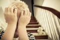 Close up of child with hands against his face