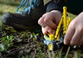 Close-up of child hands on playing in clay with yellow excavator grass boy white grass soil work play shoes