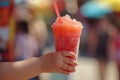 Close up of a child holding a cold slushy crushed ice drink