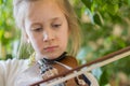 Close up of a child playing violin on green background. Portrait of girl with string and playing violin. Portrait of the little Royalty Free Stock Photo