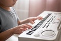 Child plays a piano keyboard. Boy learns to play the synthesizer Royalty Free Stock Photo