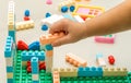 Close up, A child right hand playing with colorful plastic bricks Royalty Free Stock Photo