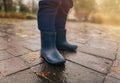 Close-up of a child in rubber boots on wet pavement after rain Royalty Free Stock Photo