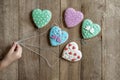 child`s hand holding gingerbread hearts for strings like balloons