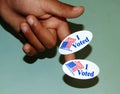 Close up of a child`s hand with two I Voted stickers