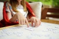 Close-up on child`s hands assembling a jigsaw puzzle on a table Royalty Free Stock Photo