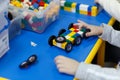 Close up of child`s hands playing with colorful plastic bricks at the table Royalty Free Stock Photo