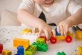 Close up of child`s hands playing with colorful plastic bricks at the table. Toddler having fun and building out of bright Royalty Free Stock Photo