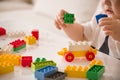 Close up of child`s hands playing with colorful plastic bricks at the table. Toddler having fun and building out of bright Royalty Free Stock Photo