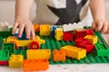 Close up of child`s hands playing with colorful plastic bricks at the table. Toddler having fun and building bricks Royalty Free Stock Photo