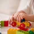 Close up of child`s hands playing with colorful plastic bricks at the table. Toddler having fun and building out of bright Royalty Free Stock Photo