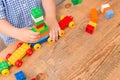 Close up of child`s hands playing with colorful plastic bricks at the table. Toddler having fun